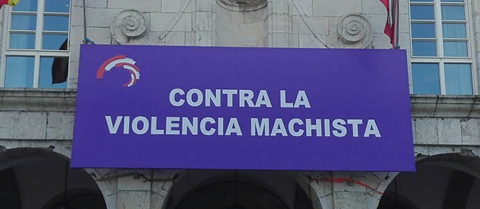 Una pancarta contra la violencia machista cuelga desde la fachada del Parlamento