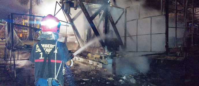 Los bomberos del 112 extinguen el incendio de una atraccin de feria en Noja