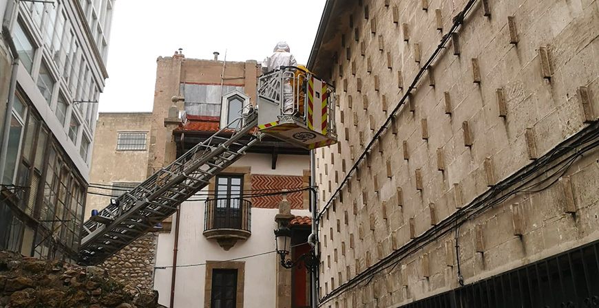 Los bomberos del 112 retiran un avispero del alero de un edificio de Reinosa