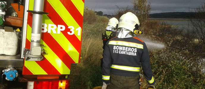 Los bomberos extinguen un incendio de vegetacin junto a la carretera entre Orzales y Monegro
