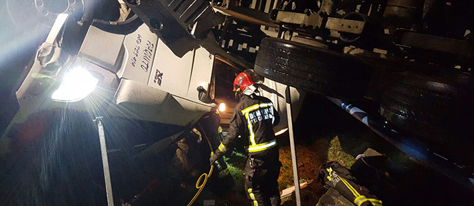 Los bomberos rescatan a un conductor herido tras salirse de la va su camin en El Escudo