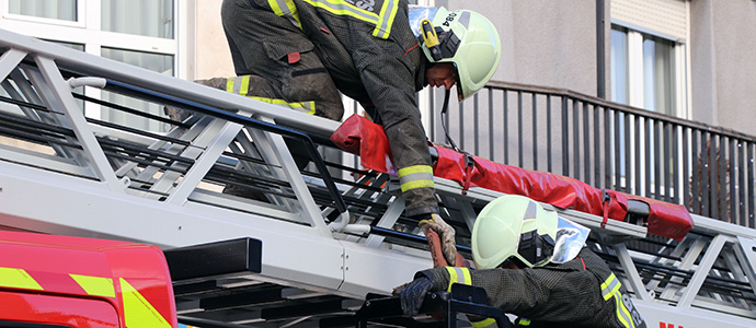 Los bomberos retiran una teja suelta en la cubierta de una vivienda de la calle Peligros