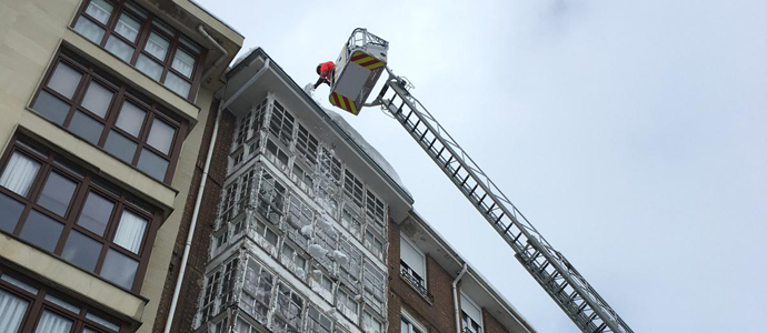 Los bomberos se han empleado a fondo para retirar la nieve de los aleros de Reinosa