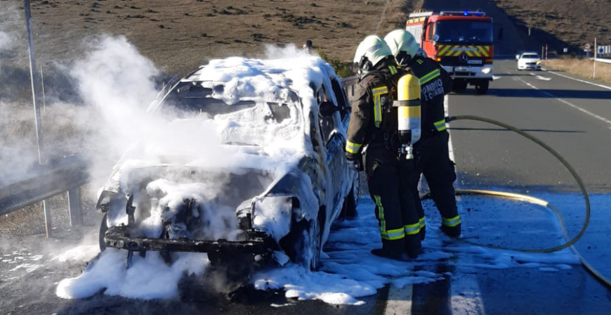 Los bomberos sofocan un incendio que se produjo en un coche cuando circulaba por la A-67 en Valdeolea 