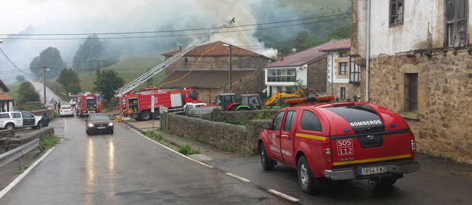 Los bomberos trabajan en la extincin de un incendio en una vivienda en Aguayo